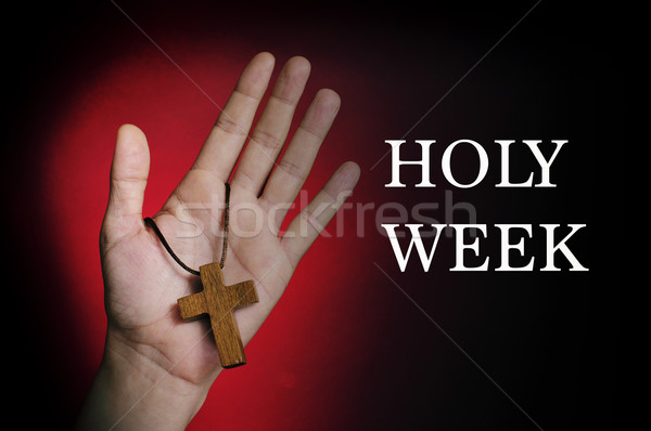 Stock photo: man hand with a wooden cross and the text holy week