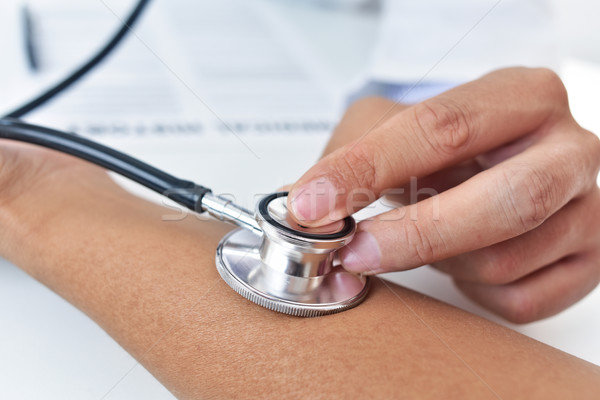 doctor auscultating the pulse with an stethoscope Stock photo © nito