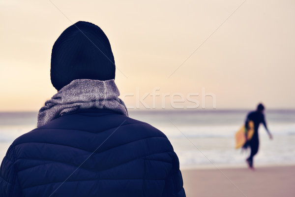 man wearing coat, scarf and knit cap in front of the ocean Stock photo © nito