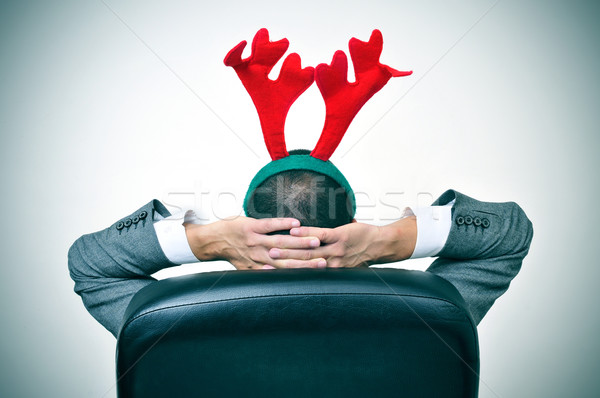 man with a reindeer antlers headband in his office chair Stock photo © nito