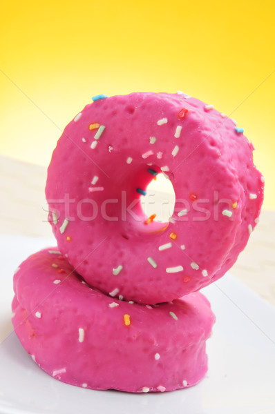 donuts coated with a pink frosting and sprinkles of different co Stock photo © nito