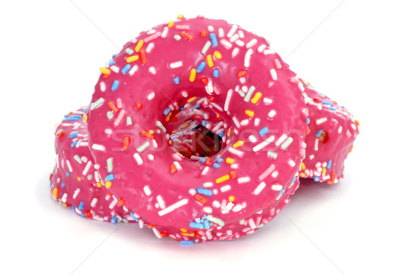 Stock photo: donuts coated with a pink frosting and sprinkles of different co