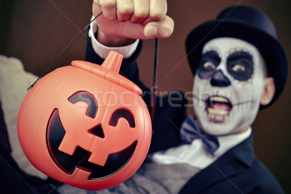 man with mexican calaveras makeup and carved pumpkin Stock photo © nito