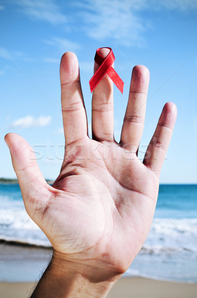 young man with a red ribbon for the fight against AIDS in his ha Stock photo © nito