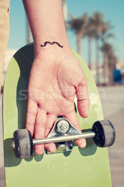 Giovane baffi tatuato mano skate Foto d'archivio © nito