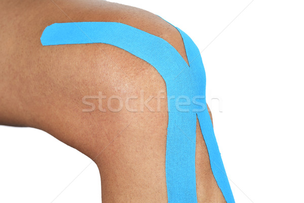 young man with an elastic therapeutic tape in his knee Stock photo © nito