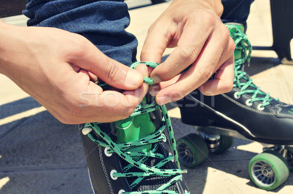 young man tying his roller skates, with a filter effect Stock photo © nito
