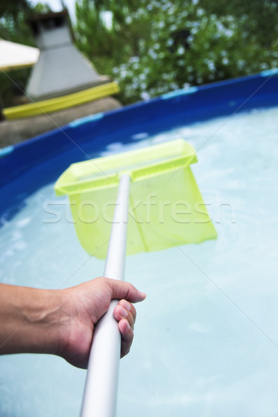 young man cleaning a portable swimming pool Stock photo © nito