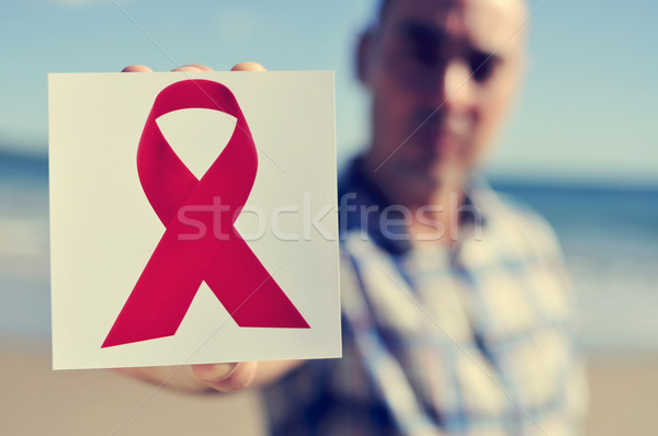 young man with a picture of a red ribbon for the fight against A Stock photo © nito