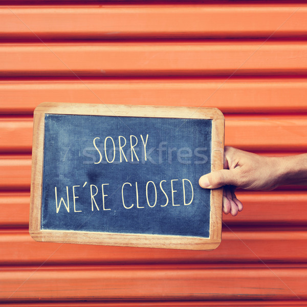 man hand with a chalkboard with the text sorry we are closed Stock photo © nito