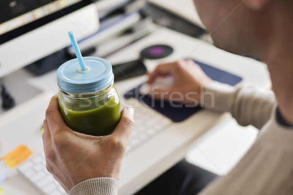 man drinking a green smoothie at the office Stock photo © nito