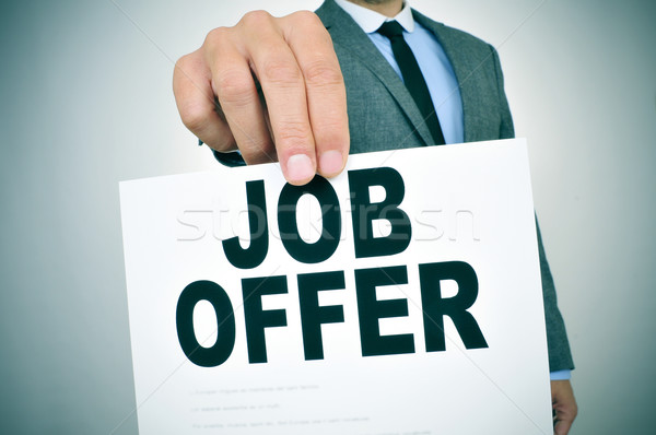 Stock photo: businessman shows a signboard with the text job offer