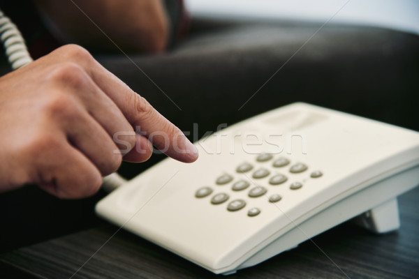 young man dialing on a landline telephone Stock photo © nito