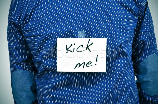 young man with a paper with the text kick me in his back Stock photo © nito