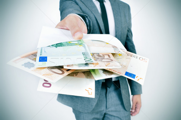 Stock photo: man giving an envelope full of euro bills