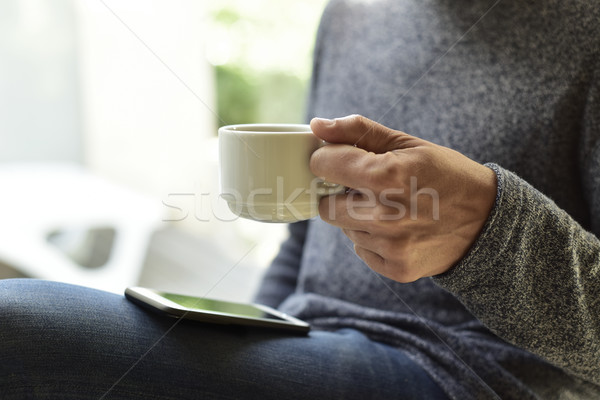 young man with a coffee using a smartphone Stock photo © nito