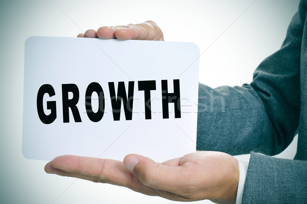 businessman showing a signboard with the text growth Stock photo © nito