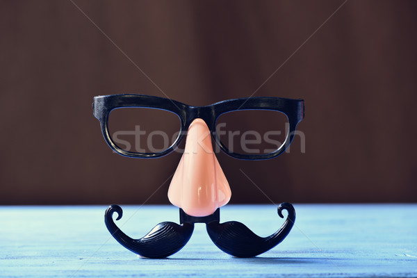 fake mustache, nose and eyeglasses on a blue surface Stock photo © nito
