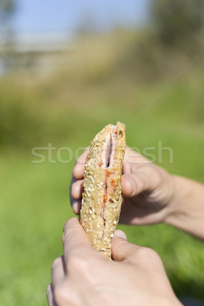 young man eating a sandwich outdoors Stock photo © nito