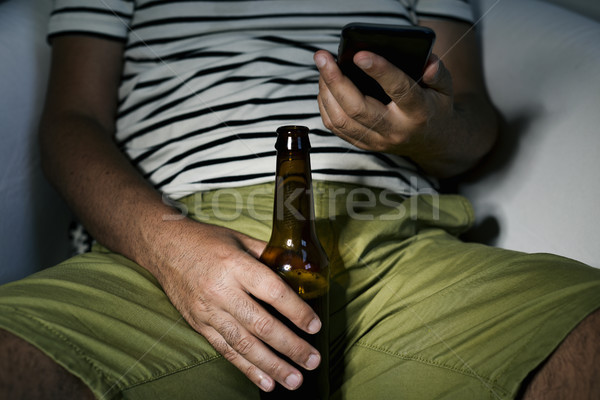 man drinking a beer and using his phone Stock photo © nito