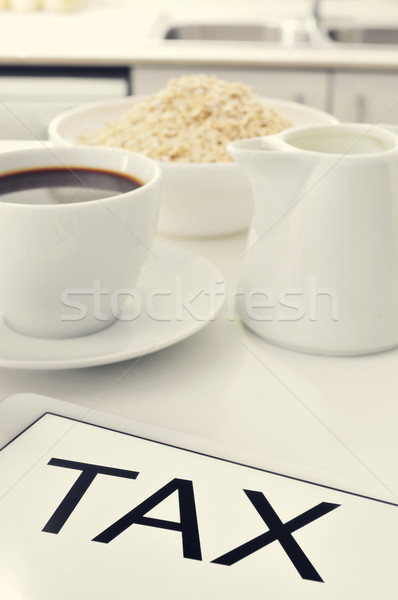 tax written in the screen of a tablet, on a set table for breakf Stock photo © nito