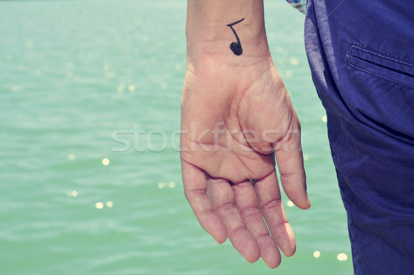 young man with a musical note painted in his wrist Stock photo © nito