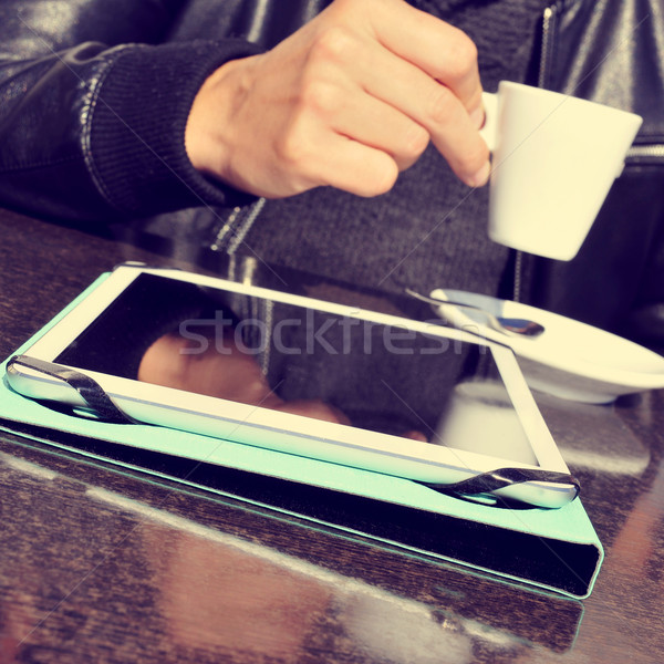 Stock photo: man with a cup of coffee and a tablet in the terrace of a cafe