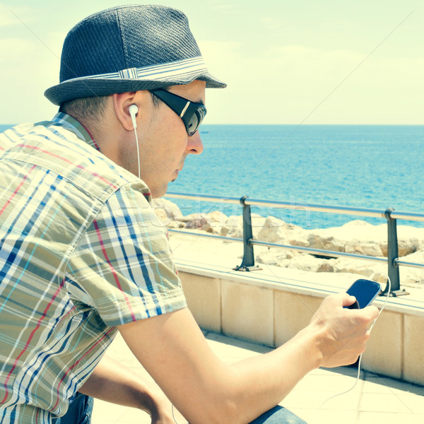 young man listening to music or talking with headphones in a sma Stock photo © nito