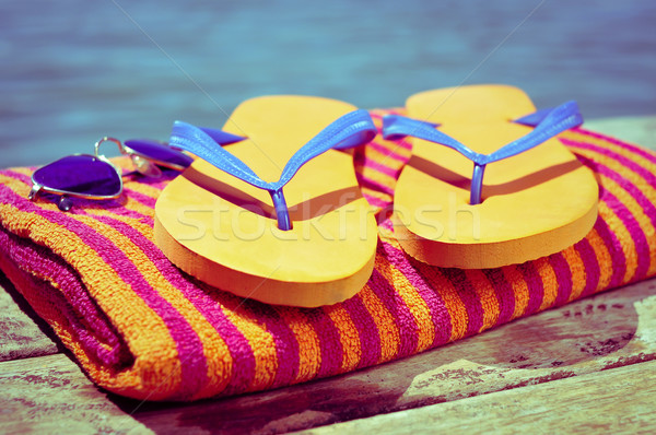 sunglasses, flip-flops and beach towel, on a wooden boardwalk Stock photo © nito