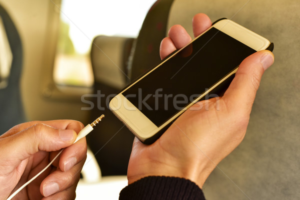 young man plugging the earphones in his smartphone Stock photo © nito