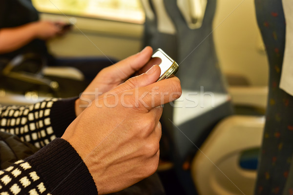 young man using a smartphone in a train Stock photo © nito