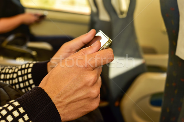 Stock photo: young man using a smartphone in a train