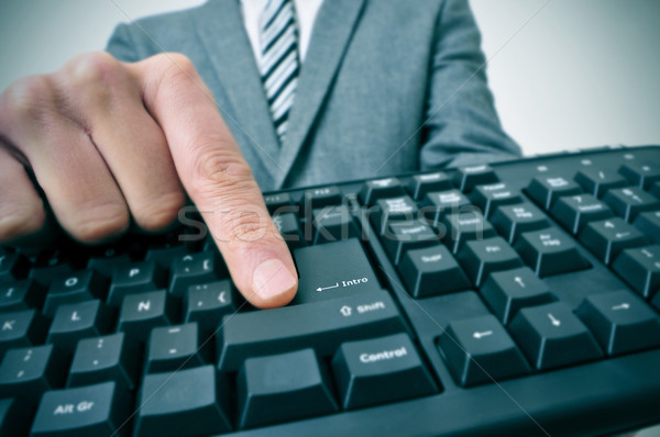 businessman pressing the intro key of a computer keyboard Stock photo © nito
