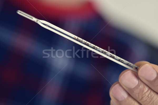 Stock photo: man with a medical thermometer in his hand