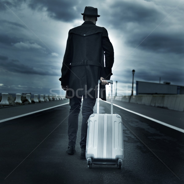 young man with a rolling suitcase, with a dramatic effect Stock photo © nito