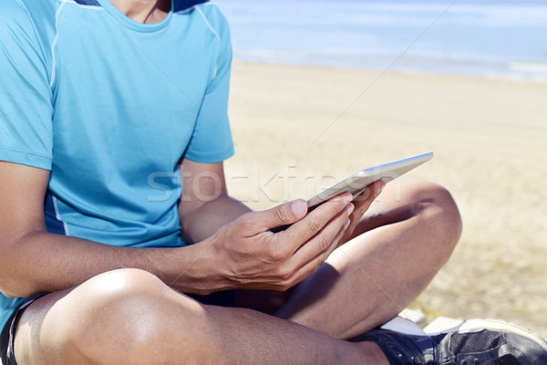 young sportsman using his tablet computer Stock photo © nito