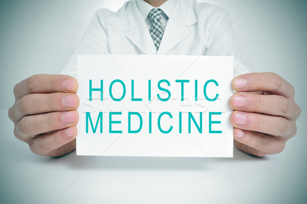 doctor with a signboard with the text holistic medicine Stock photo © nito