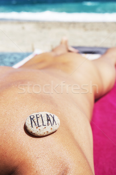 Stock photo: man on the beach and text relax in a stone
