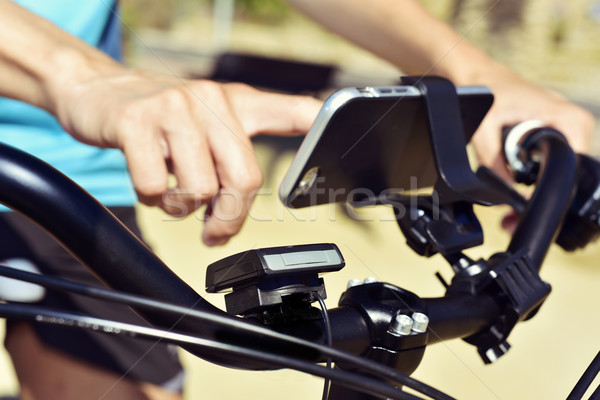 young man using a smartphone riding a bicycle Stock photo © nito
