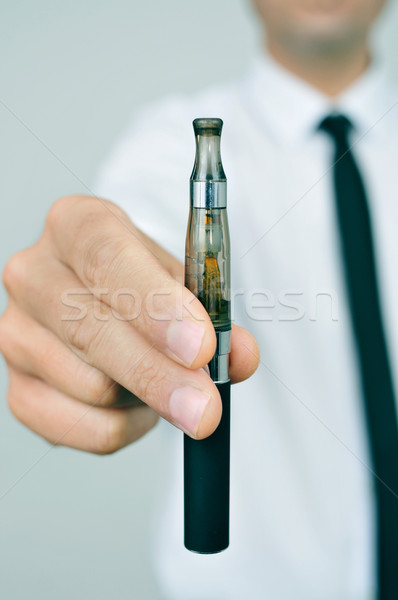 Stock photo: young man showing an electronic cigarette