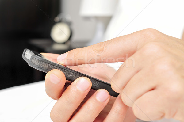 young man using a smartphone in bed Stock photo © nito