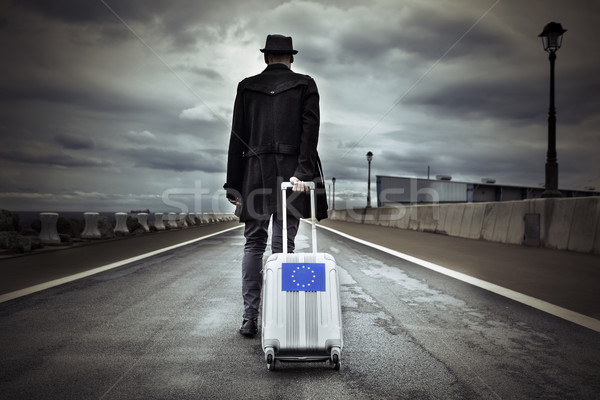 young man with a rolling suitcase with an European flag Stock photo © nito