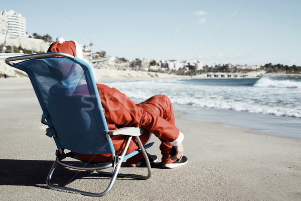 Mikulás tengerpart mögött ül nyugágy okostelefon Stock fotó © nito