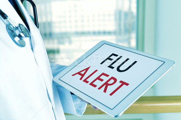 Stock photo: doctor with a tablet with the text flu alert