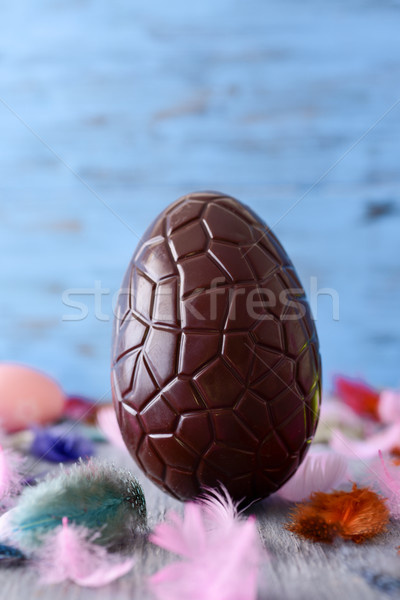 Csokoládé húsvéti tojás közelkép rusztikus fa asztal tollak Stock fotó © nito