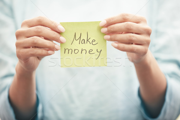 Woman holds adhesive paper with Make money text Stock photo © Novic