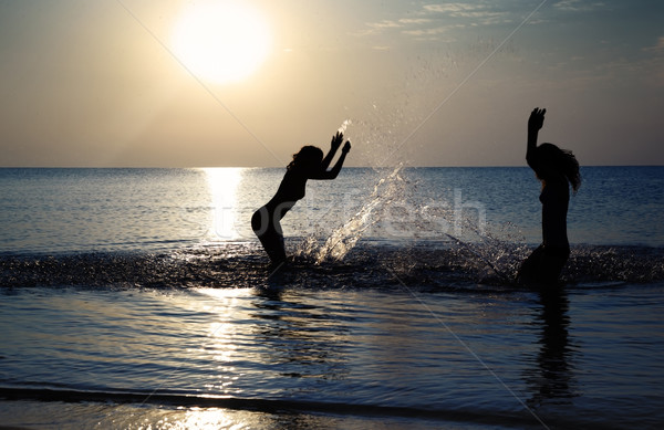 Giocare spiaggia sagome due ragazze acqua Foto d'archivio © Novic