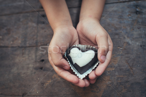 Love note on black and white chocolate in kid's hand Stock photo © nuiiko