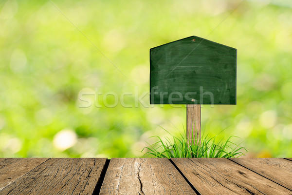 Wooden blackboard sign in grass and bokeh background Stock photo © nuiiko