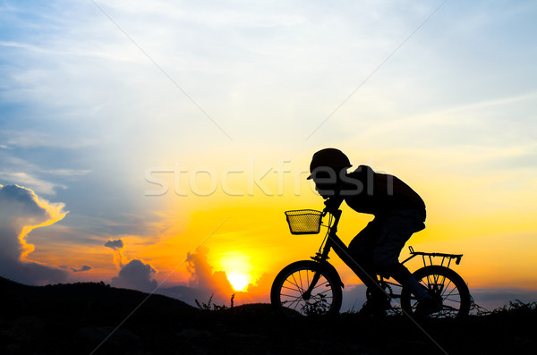 Silhouette of the cyclist riding a road bike at sunset Stock photo © nuiiko